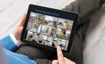 Man looking at home security cameras on tablet computer
